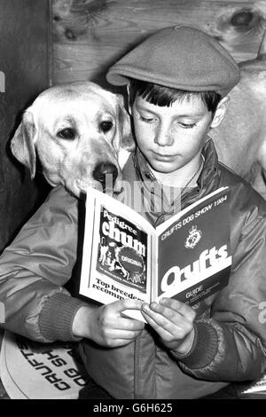 Steven McEwan, 10, from Eastriggs, Dumfries, reads the programme at the 88th Crufts dog show at Earls Court. He is with his Labrador Honey. Stock Photo