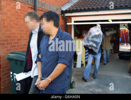 Police officers escort an arrested man and carry away evidence after a dawn raid on a property in east London. Scotland Yard announced later that they had smashed a major international drug and money laundering operation during a series of co-ordinated raids across the capital. The raids - 23 in London and up to another 25 in Colombia - were the final phase of a two-year operation targeting the biggest cocaine importation and money laundering ring ever uncovered in the UK. Stock Photo