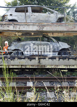 Burnt out cars are inspected in the sidings of Oxenholme station near Kendal. Hundreds of rail passengers had to put up with delays and cancellations after a freight train carrying motor cars caught fire on a main London to Scotland line. One London-bound sleeper train was three hours late arriving and another was nearly two hours delayed. The West Coast Main Line was shut for several hours and a number of First North Western trains were cancelled. The fire was on an EWS freight train taking Citroen and Peugeot cars from Washwood Heath near Birmingham to Bathgate in West Lothian, Scotland. Stock Photo