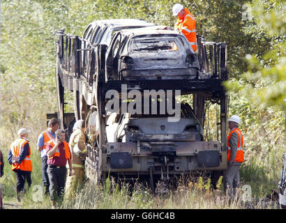 Burnt out cars are inspected in the sidings of Oxenholme station near Kendal. Hundreds of rail passengers had to put up with delays and cancellations after a freight train carrying motor cars caught fire on a main London to Scotland line. One London-bound sleeper train was three hours late arriving and another was nearly two hours delayed. The West Coast Main Line was shut for several hours and a number of First North Western trains were cancelled. The fire was on an EWS freight train taking Citroen and Peugeot cars from Washwood Heath near Birmingham to Bathgate in West Lothian, Scotland. Stock Photo