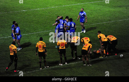 The Samoan team celebrate after Sauaso Sue scores a try as Papa New Guinea stand dejected during the 2013 World Cup match at Craven Park, Hull. Stock Photo