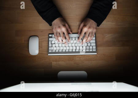 Top view of hands of young man typing on keyboard Stock Photo
