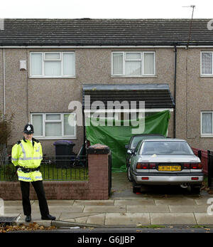 A police officer stands outside the house in Chatsworth Drive, Liverpool, where a six-year-old girl is being treated in hospital, along with two members of her family after being shot at their home last night. The youngster, along with a woman aged 35 and a man aged 19, was shot at around 9.30pm yesterday at the house in Kensington, Liverpool. Stock Photo