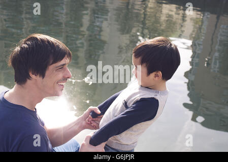 Father and little boy hanging out by river Stock Photo