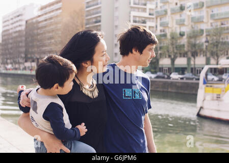 Family strolling down riverbank in city Stock Photo