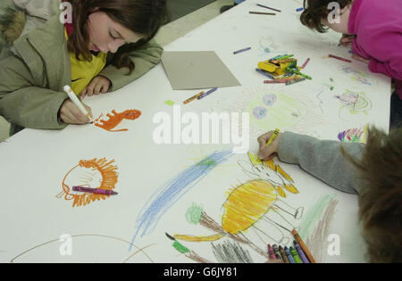 Hannah Clarke (left), nine and her brother Joe, six, from Stroud Green in north London, join other children and adults to take part in the British Museum's 'The Big Draw' event held inside the museum in central London. The themes of this year's 'The Big Draw' are 'The British Museum's 250th anniversary' and 'Portraiture across the cultures'. Visitors were encouraged to draw inspiration from cultures around the world and join in with drawing the faces of Ancient Iraq, the hieroglyphs of Ancient Egypt and the cave art of Stone Age Europe. Stock Photo