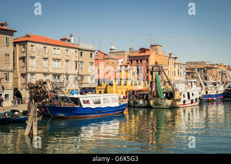 Chioggia, Italy - May 20, 2016: Fishing boats moored in a canal in Chioggia, Venetian Lagoon, Italy. Stock Photo