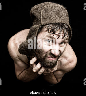 Dark portrait of scary evil sinister bearded man with smirk, makes various hand's signs and expresses different emotions. strange Russian man Stock Photo