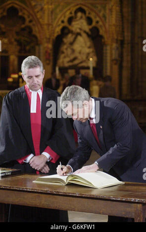 US President George Bush signs the Distinguished Visitors' Book inside Westminster Abbey in central London as the Dean, The Very Reverend Dr Wesley Carr watches. The President laid a wreath at the Tomb of Unknown Soldier before travelling to Downing Street for talks with Tony Blair. Stock Photo