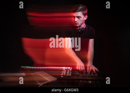 Handsome young dj using laptop and playing music Stock Photo