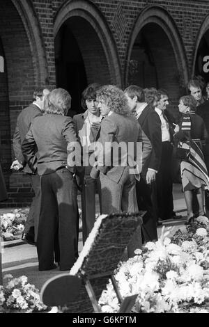 Roger Daltery (r), of the rock band The Who, talking with Rolling Stones Bill Wyman (facing camera) and Charlie Watts (right, partially hidden) at Golders Green Crematorium in North London to attend the funeral of Keith Moon, the drummer of English rock group The Who, who died from a drug overdose. 13/09/1978 Stock Photo