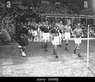 The two teams are led onto the field by their captains before the start of the game. Rest of Europe (l) are wearing dark shirts and Great Britain (r) are wearing light shirts. Before a crowd of 134,000 at Hampden Park, Glasgow, Great Britain piled up six goals against the Rest of Europe, who, disheartened after a three-goals-in-three-minutes spell in the first half, were able to score only once in reply. Stock Photo