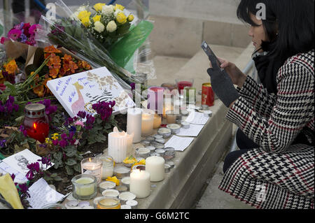 Flowers and tributes beside the Nelson Mandela statue in Westminster Square, central London after the death of the former South African president on Thursday evening. Stock Photo