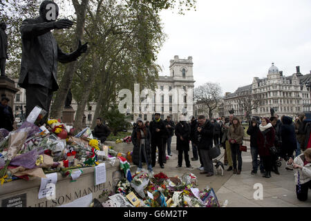 Flowers and tributes beside the Nelson Mandela statue in Westminster Square, central London after the death of the former South African president on Thursday evening. Stock Photo