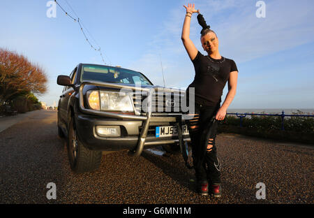 Circus of Horrors performer Anastasia IV pulls a four tonne vehicle along the seafront in Eastbourne, Sussex, as the circus prepare to perform a series of shows across the region later this month. Stock Photo