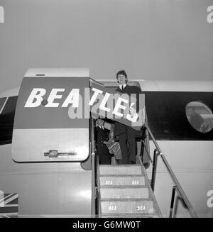 Ringo Starr, drummer of The Beatles, signs off - with the aid of BEA - as he boards an airliner at London Airport to join the three other members of the group in Paris. The other Beatles flew out yesterday, while Ringo Starr was fog-bound in Liverpool and unable to get to London in time to travel with them. Stock Photo