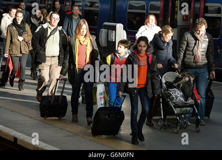 A group of travellers make their way to waiting trains as the expected Christmas rush starts, at King's Cross Train station in central London, on what is expected to be one of the busiest days of the year for travelling. Stock Photo