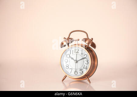 Retro alarm clock on a peach background Stock Photo