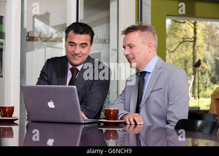 Confident and successful business partners brainstorming ideas in a large cooperate modern office, could also be client advice Stock Photo