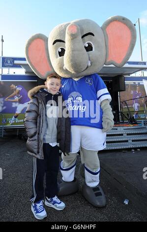 Young Everton fans pose for a photograph with Everton mascot Changy the Elephant Stock Photo