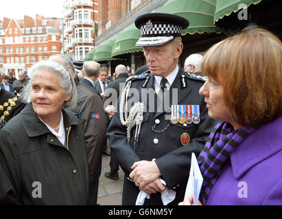 Former police officer Pam White (right), who was standing next to her colleague Constable Jane Arbuhnot, who died when a car bomb exploded outside Harrods, with Jane's mother Susan Arbuthnot, talk to the Metropolitan Police Commissioner Sir Bernard Hogan-Howe, as they attend a memorial service at the Harrods Bombing memorial, on the 30th anniversary of the terrorist attack which left three Police Officers and three members of the public dead, on December 17, 1983, outside the landmark department store in west London. Stock Photo