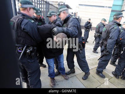 FACES PIXELATED BY PA PICTURE DESK Police arrest a supporter of three men in custody outside Belfast Magistrates' Court, Colin Duffy who has been charged with conspiring to murder members of the security forces in Northern Ireland and the other two men who were separately accused of trying to murder police travelling to the scene of a loyalist protest in Belfast earlier this month. Stock Photo