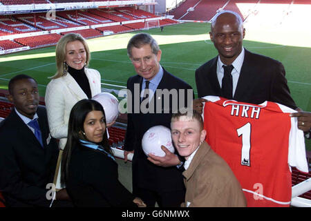 The Prince of Wales (centre) is presented with an Arsenal shirt by club captain Patrick Vieira as he visits Arsenal FC's Highbury stadium in north London, watched by sports presenter Gabby Logan (back row left) and (front row from left) Mark Olugosi, Asha Vagella and Kevin Johnson to celebrate the sixth anniversary of The Prince's Trust Football Initiative. The Prince's Trust Football Initiative uses the appeal of football to motivate youngsters aged 16-25, and is funded by the FA Premier League, the Football Foundation and the Professional Footballers Association. Stock Photo
