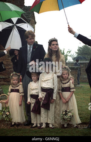 Viscount Althorp joins hands with his bride Victoria Lockwood after their wedding ceremony at St. Mary's Church in Great Brington, Northamptonshire. Page boys Prince Harry and Alexander Fellowes, alongside bridesmaids Emily McCorguodale and Eleanor Fellowes, are also with them. Stock Photo