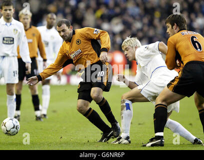 Leeds United's Alan Smith tussles with Wolverhampton Wanderes Colin Cameron (left) & Paul Butler (right), during the Barclaycard Premiership match at Molineux, Wolverhampton. Stock Photo