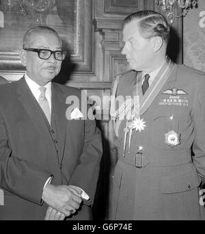 Air Chief Marshal Sir John Grandy, who earlier this year upon relinquishing his appointment as Commander-in-Chief Far East was invested by the Queen with the Insignia of a Knight Grand Cross of the Most Honourable Order of the Bath (Military Division), seen with the Malaysian Prime Minister, Tunku Abdul Rahman (left), after he invested him with the award of the Malaysian 'Tan Sri', equivalent to a knighthood, for meritious service to the nation, at the malaysian High Commission, in London. Stock Photo