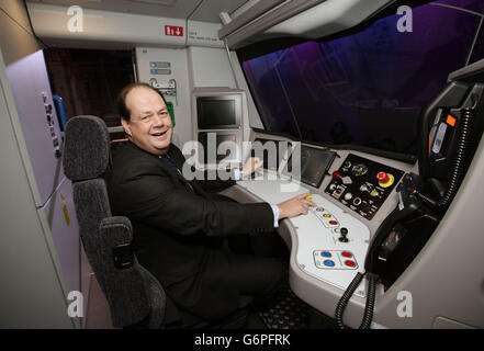 Rail Minister Stephen Hammond sits in the cab of a full-scale mock-up of the next-generation Thameslink train, during its unveiling, delivered as part of the Government's &pound;6.5bn Thameslink Programme - at ExCeL exhibition centre in London. Stock Photo