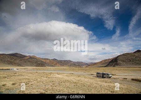 two cars on the side of a highway to west in the landscape of western Mongolia Stock Photo