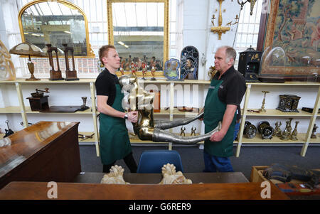 RETRANSMITED CORRECTING CAPTION (NOTE CONTENT) Lee Cox (left) and Tim Allcorn (right) sale room porters at Bellmans Auctioneers in Wisborough Green, West Sussex, carry a piece by Rudolfo Bucacio, a gilt bronze scale figure of a scantily clad young lady into the sale room as a collection of his work features in a sale of antiques and interiors at the auction house later this week. Stock Photo