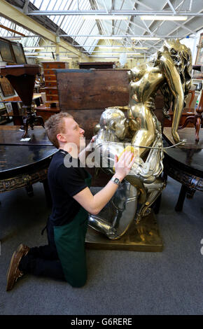 RETRANSMITED CORRECTING CAPTION (NOTE CONTENT) Lee Cox, sale room porter at Bellmans Auctioneers in Wisborough Green, West Sussex, prepares a piece by sculptor Rudolfo Bucacio entitled Techno Lover, as a collection of his work features in a sale of antiques and interiors at the auction house later this week. Stock Photo