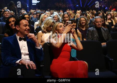 Craig Revel Horwood and Abbey Clancey take photographs during the 2014 National Television Awards at the O2 Arena, London. Stock Photo