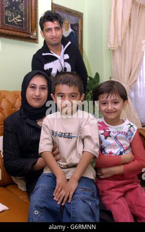 Husband and wife Fraidon (rear) and Palwasha Sharifi, their children Munilla (right) and Hasib at their home in north London. Later Thursday February 26, 2004, the family are taking part in the UK's first citizenship ceremony, when they will be in a group of 16 people from countries including Afghanistan, Somalia and Poland who will sing the National Anthem, take an oath of allegiance to the Queen and give a citizenship pledge. The ceremonies are designed to make acquiring a British passport more of an occasion, and to formally welcome new citizens into their local community. Stock Photo