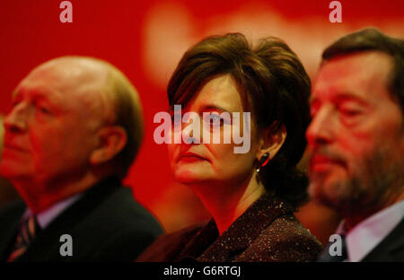 Cherie Blair, listens to her husband's keynote speech as she sits between former Labour leader Neil Kinnock (left) and Home Secretary David Blunkett, on the second day of the Labour spring conference at the Manchester International Conference centre. Mr Blair acknowledged that today's conference, designed originally as a tub-thumping exercise ahead of local council and MEP elections in June, 'takes place under the shadow of events in Spain'. Stock Photo