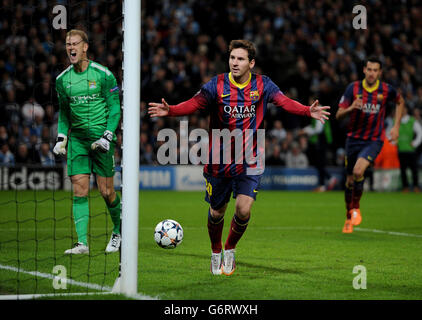 FC Barcelona's Lionel Messi celebrates scoring his teams 1st goal past Manchester City's Joe Hart (left) during the UEFA Champions League, Round of 16 match at the Etihad Stadium, Manchester. Stock Photo