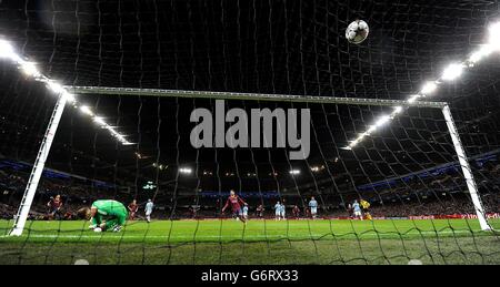 FC Barcelona's Lionel Messi scores his teams 1st goal past Manchester City's Joe Hart, during the UEFA Champions League, Round of 16 match at the Etihad Stadium, Manchester. Stock Photo