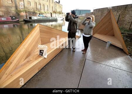 Project Officer Martin Thompson (left) and the Regional Development Manager for north London Jo Mould (right) study the vista from the new floating viewpoint produced for the London Wildlife trust on the Regent's Canal, behind King's Cross station in Camden, which was designed by Finnish Architects Erkko Aarti, Arto Ollila, & Mikki Ristola. Stock Photo