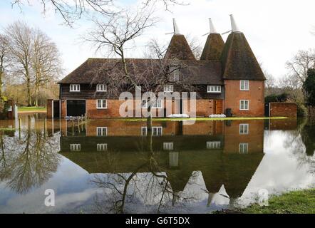 Floodwater surrounds an oast house in Littlebourne, Kent, as river levels continue to rise in the area. Stock Photo