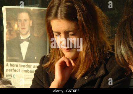 Claire McIntosh, 22, from Eglish, Co Tyrone, Northern Irelands, standing outside Eglish Post Office, waiting for the funeral cortege of Cormac McAnallen to enter the Parish Church opposite. Mr McAnallen, who was captain of the Tyrone GAA football champions, died suddenly of a heart infection earlier in the week. A newspaper photo of Mr McAnallen can be seen stuck to the window of the Post Office. Stock Photo