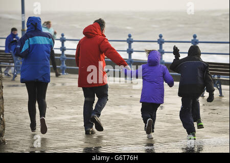 People struggle to make their way along the Esplanade, Porthcawl, south Wales, as the region continues to be battered high winds and heavy rain. Stock Photo