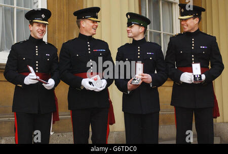 Irish Guards (from left) Lieutenant Thomas Orde-Powlett, Major Peter MacMullan, Guardsman Anton Branchflower and Lieutenant Daniel O'Connell after being decorated by the Queen with Military Crosses, except for Major MacMullen who received an MBE after being decorated by Britain's Queen Elizabeth II at an investiture for services in Iraq at Buckingham Palace, London. Stock Photo