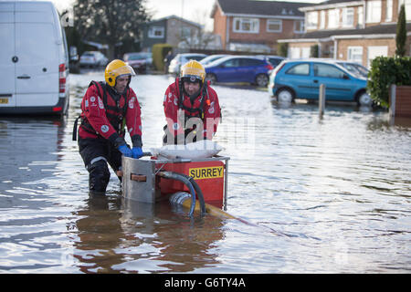 Members of the Surrey Fire and Rescue Service make adjustments to a high volume pump (HVP) to remove water from a housing estate in Staines-upon-Thames. Stock Photo