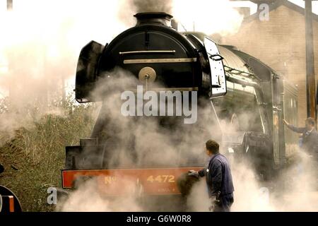 Jim Rees, Vehicle Collections Manager inspects the Flying Scotsman, one of the world's most famous locomotives running on Britain's railways, pictured at it's sidings in west London. The National Railway Museum (NRM) in York, has launched an appeal to raise the funds needed to prevent the Flying Scotsman from going abroad, the museum's bid today topped 220,000 just two weeks before the deadline to buy the rail icon. 05/04/2004 The world-famous steam locomotive, has been saved from the prospect of sale abroad to run passenger trips in Britain, it was announced Monday April 5, 2004. The Stock Photo