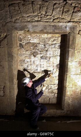 Stonemason Gordon Macgregor finishes uncovering a hidden doorway in the Guard Hall of Stirling Castle in Scotland. Restoration and renovation work is taking place at the castle, removing plaster and plaster board which has been on the walls and ceilings for more than a 120 years, as part of a project to recreate its Royal Apartments to their former splendour. Several hidden doorways in the Queen's Presence Chamber and in the Gallery leading to the Queen's Guard Hall have been uncovered during the work which will be used to determine the look of the Royal Apartments in the Palace during the Stock Photo