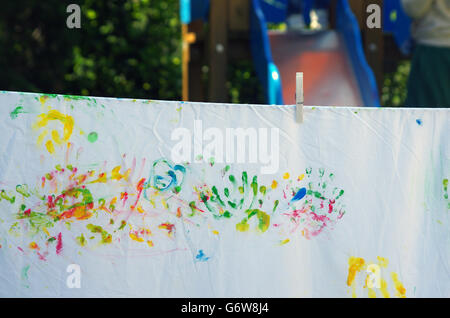 children playing making colorful designs with hands dipped in colored dye Stock Photo