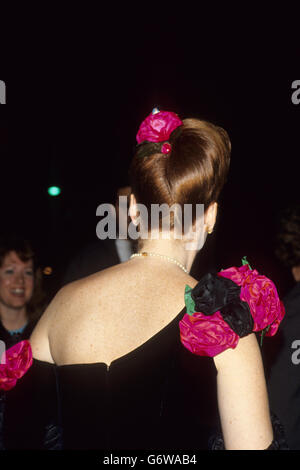 Sarah Ferguson, the Duchess of York, wears a black evening dress decorated with pink roses at the shoulder and in her hair as she attends fashion shows at a Los Angeles nightclub with the Duke (not pictured).