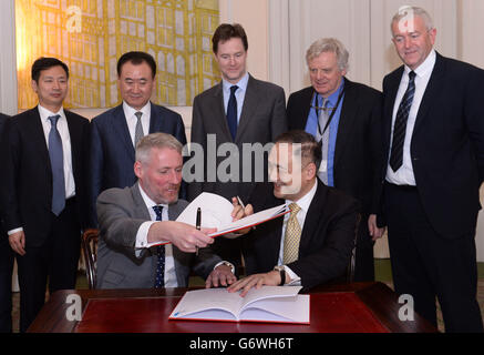 Andrew Smith (front left) of Pinewood Studios signs a consultancy services agreement with President Hu (front right) of Dalian Wanda Group, as Deputy Prime Minister Nick Clegg (centre) and Lord Michael Grade (2nd right) in London. Stock Photo